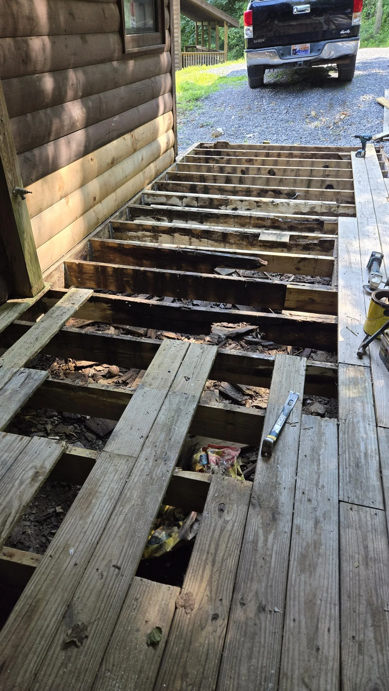 The same deck in August 2024 with the boards off, showing the joists underneath