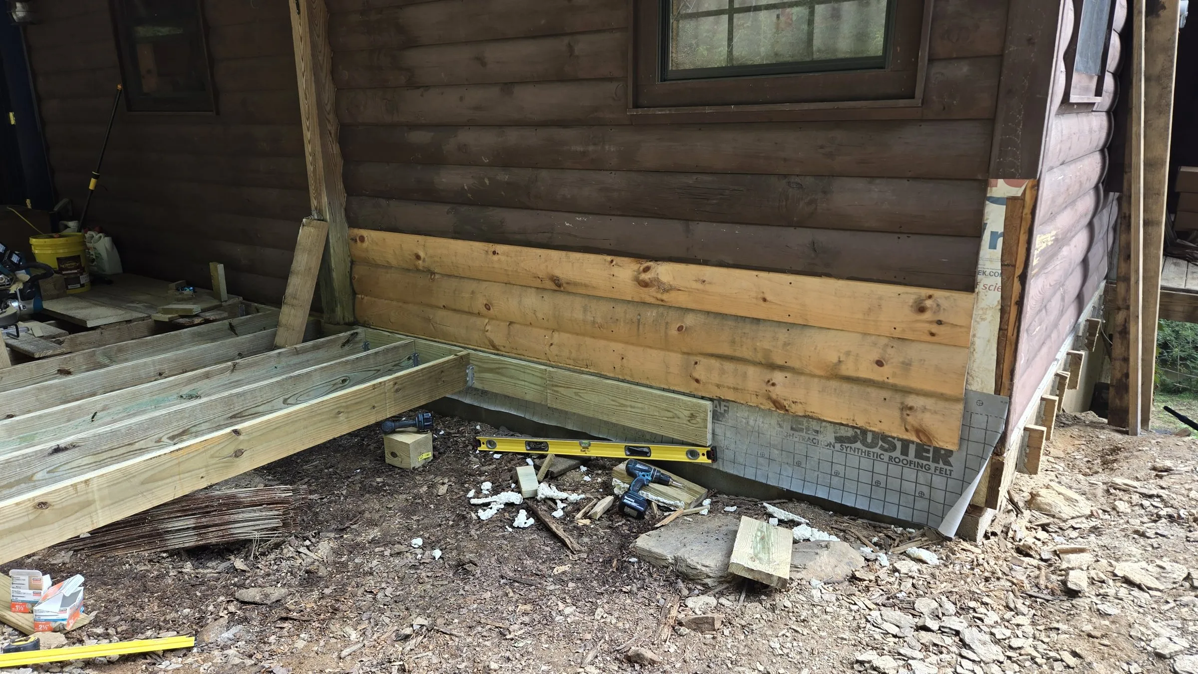 New deck framing set level against the cabin wall