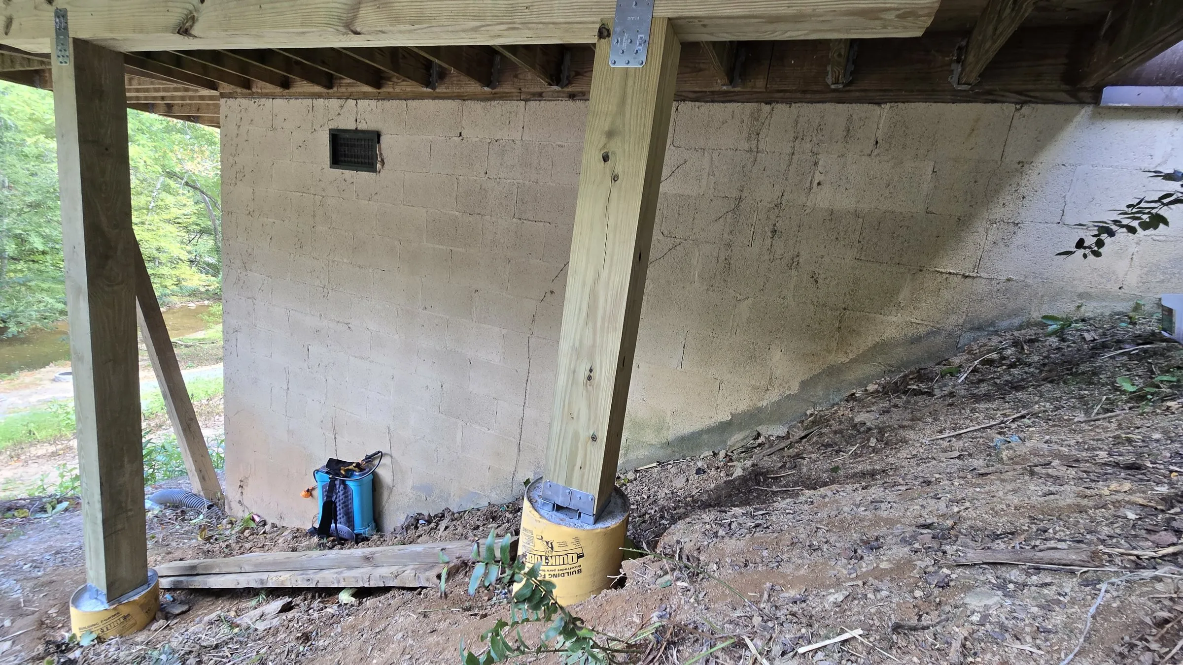 New post standing on a concrete footing with a metal post base